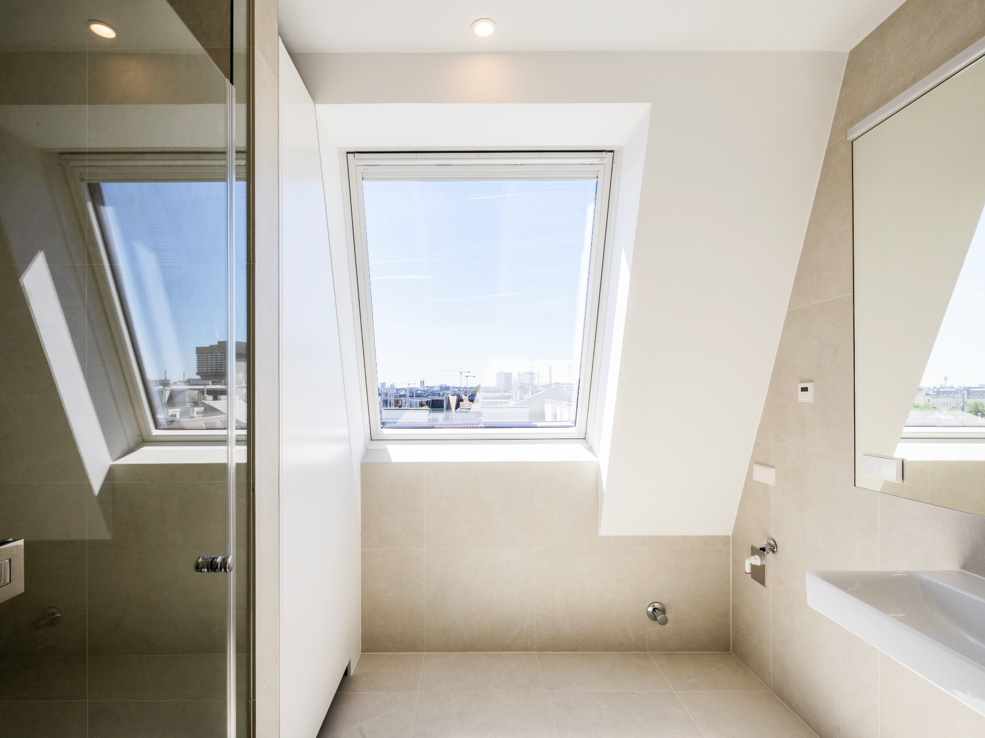 Lichtdurchflutetes Dachbadezimmer mit Stadtblick